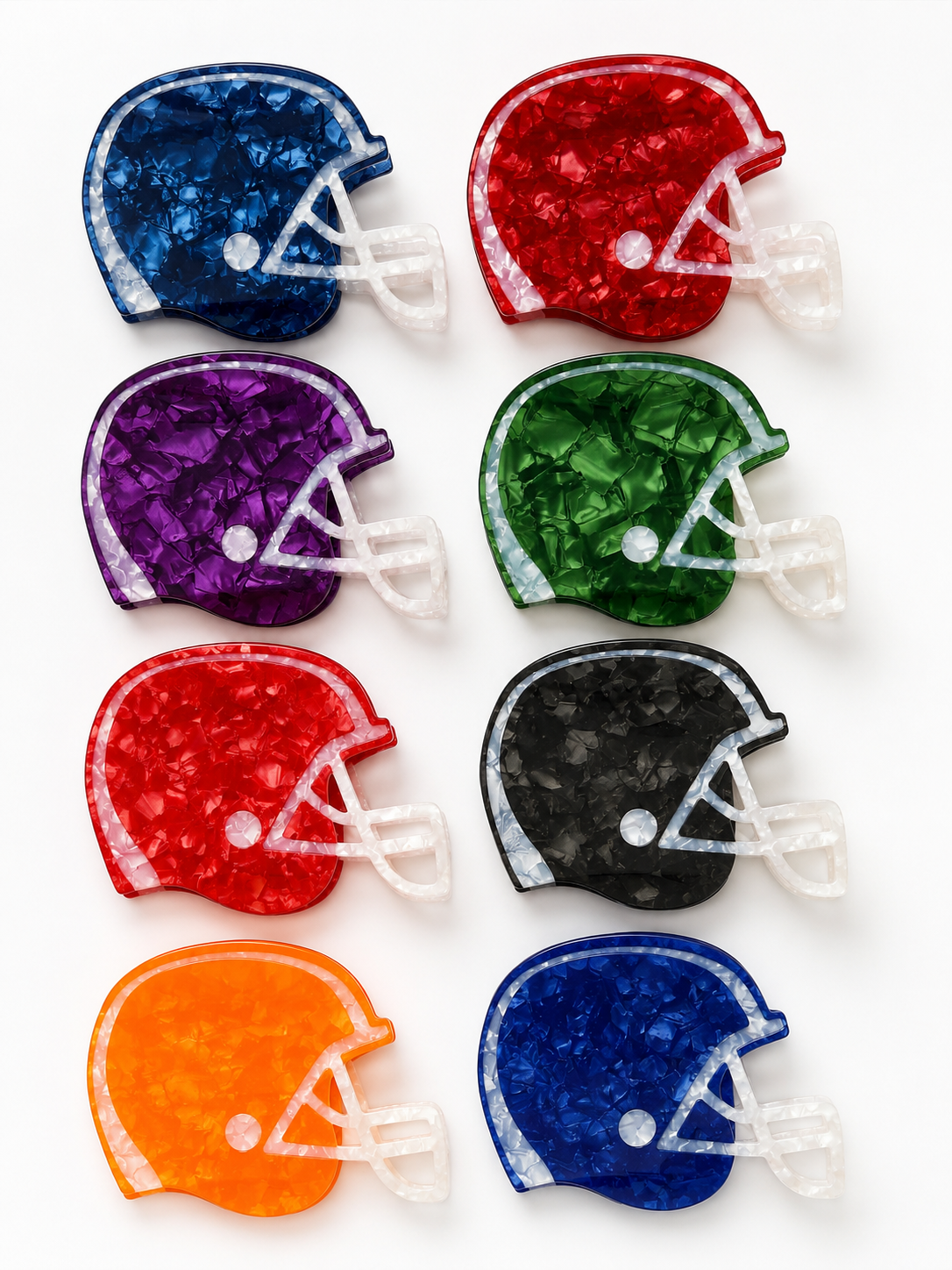 Eight football helmet-shaped hair claws arranged in a 2x4 grid on a white background, each in a different color: navy, red, purple, green, maroon, black, orange, and royal blue. The items have a textured, crackled finish with white faceted details representing laces and faceguard.