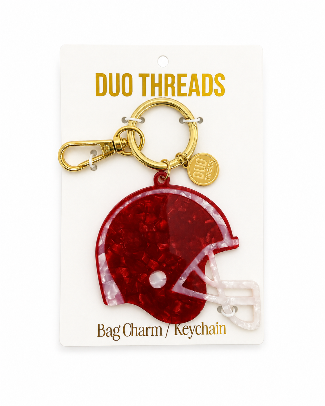 A maroon football helmet bag charm keychain by Duo Threads, attached to a gold clasp and displayed on its white backing card.