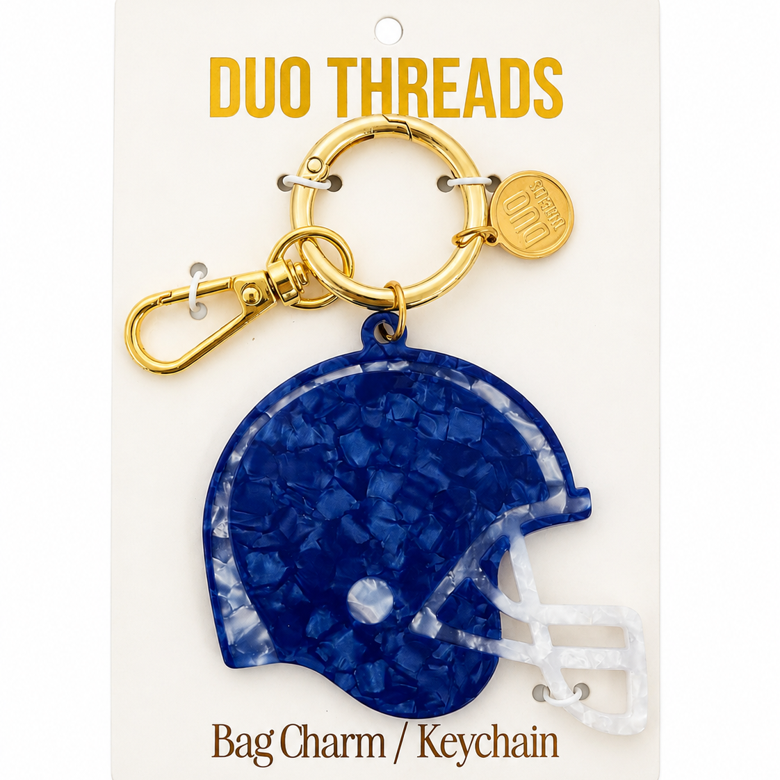 A royal blue football helmet-shaped bag charm keychain by Duo Threads, attached to a gold-tone split ring and clasp, displayed on its white backing card.